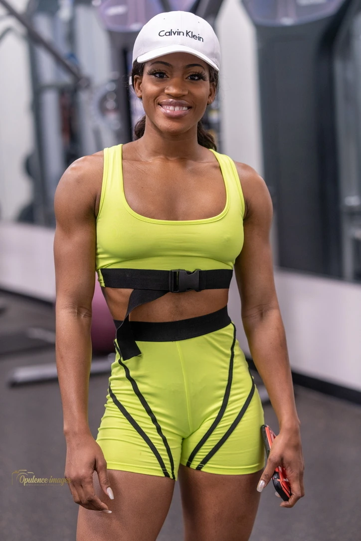 Shay Lorjuste in a personal branding gym portrait wearing a yellow training outfit.