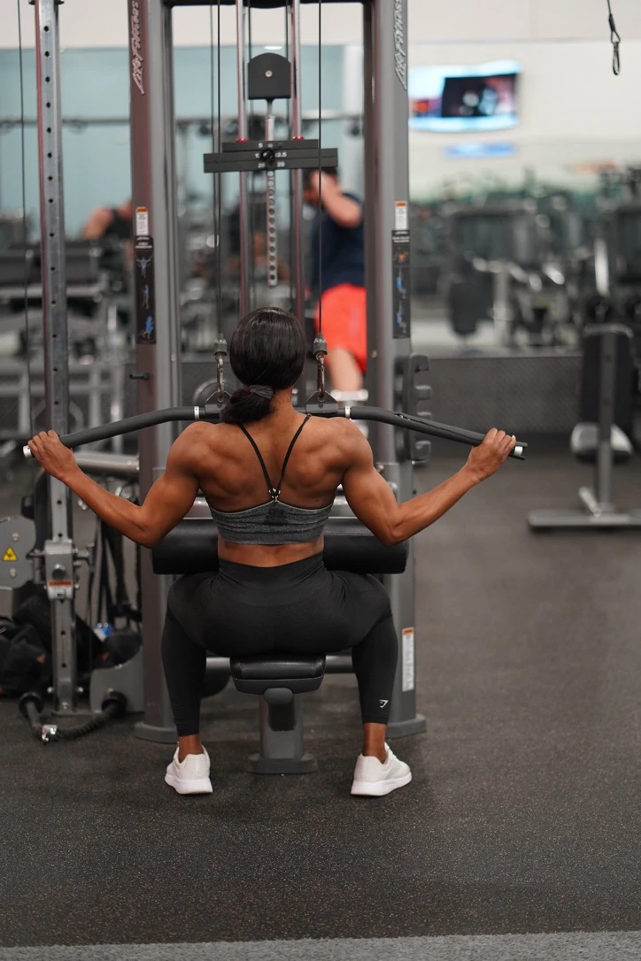 Shay Lorjuste training on a lat-pulldown machine in a gym.