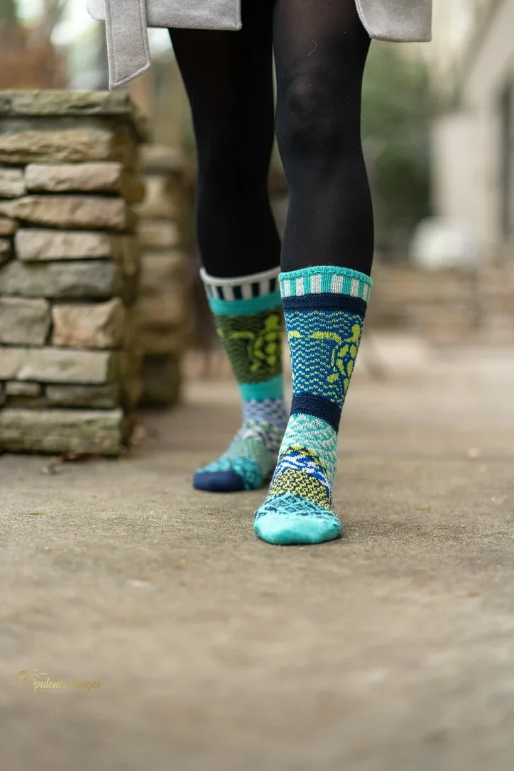 Colorful socks styled with leggings and boots.