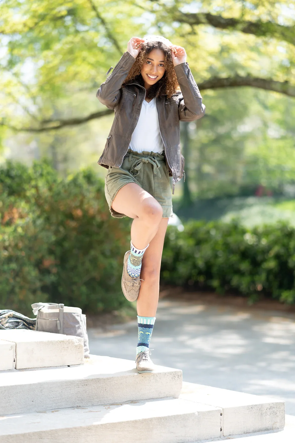 Patterned socks and sneakers in a playful pose on sunlit steps.
