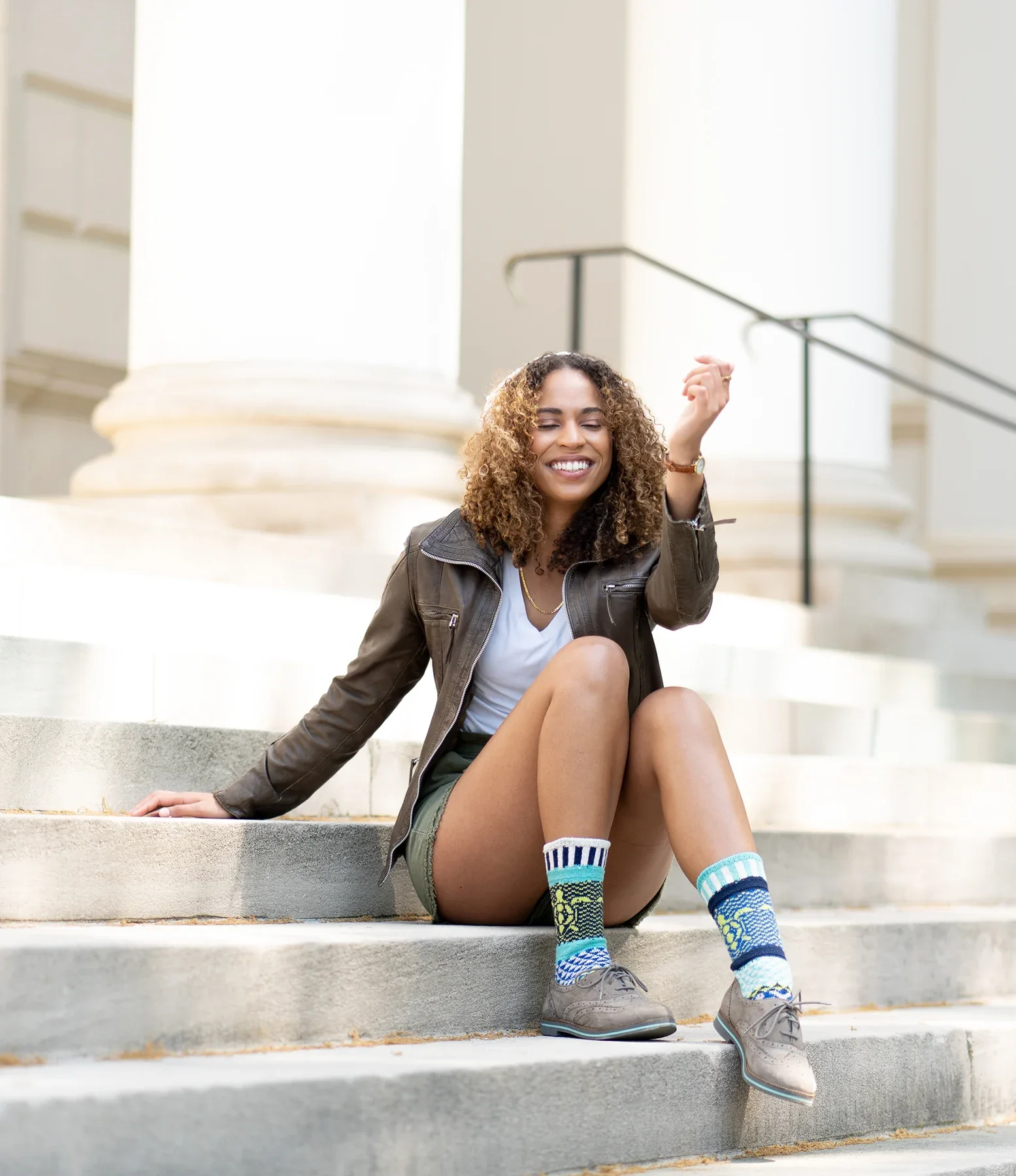Solmate Socks styled in a sunlit portrait on stone steps.