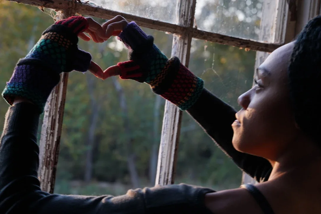 Fingerless gloves — lifestyle portrait by a window.
