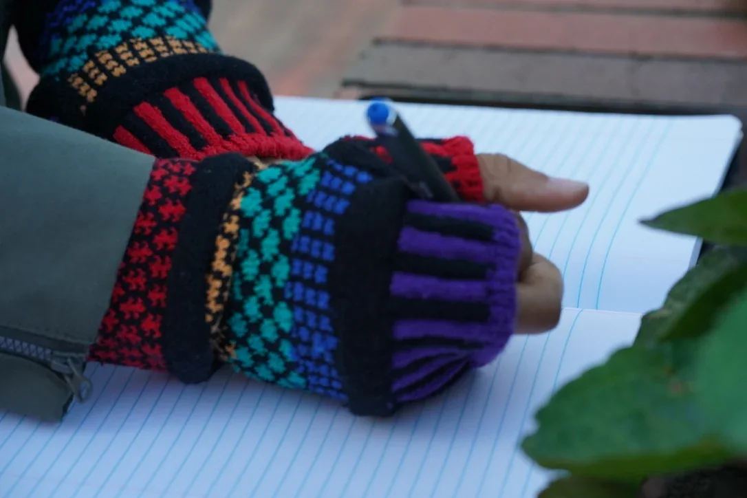Fingerless gloves for everyday work — writing detail.
